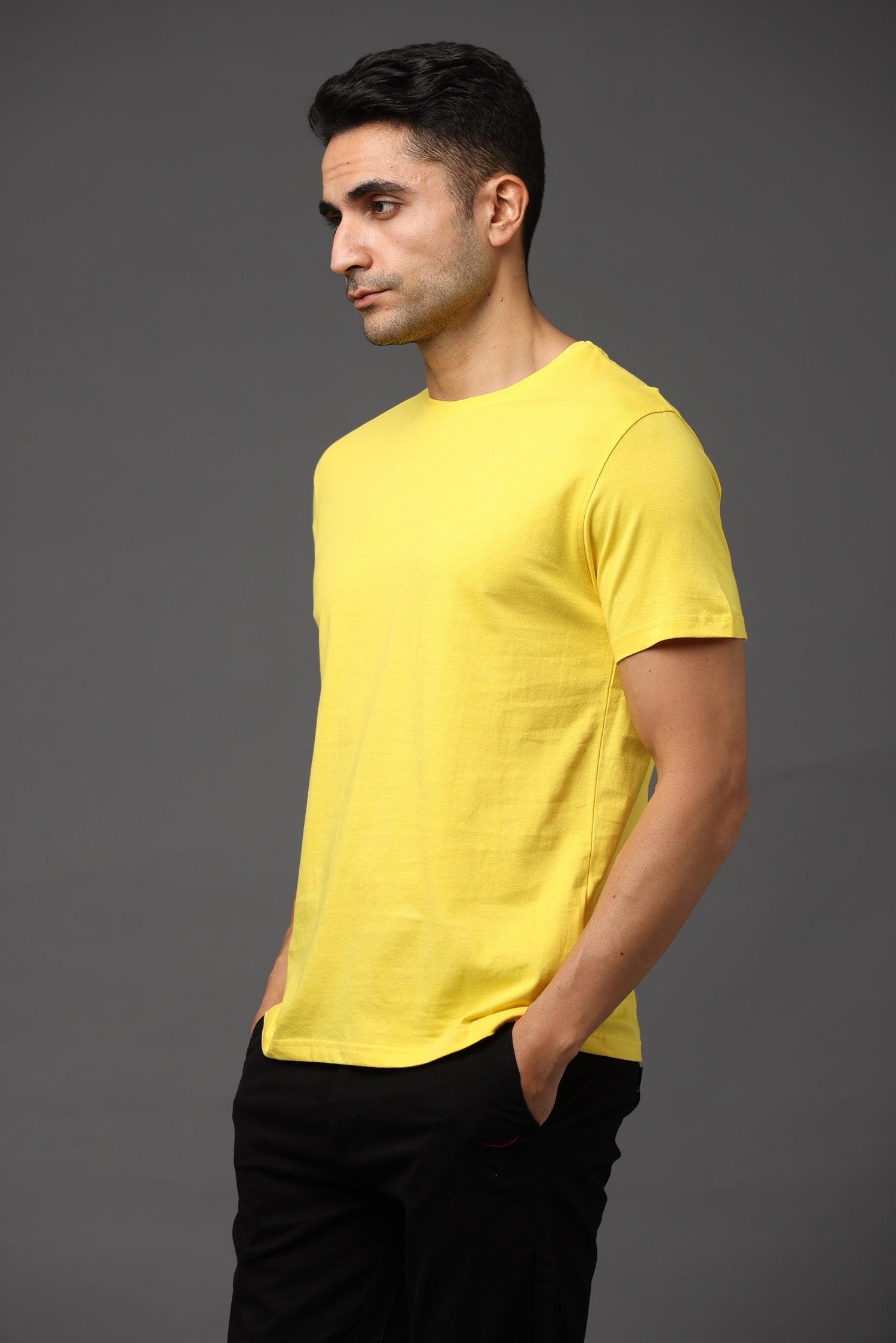 Man wearing a yellow t-shirt against a gray background