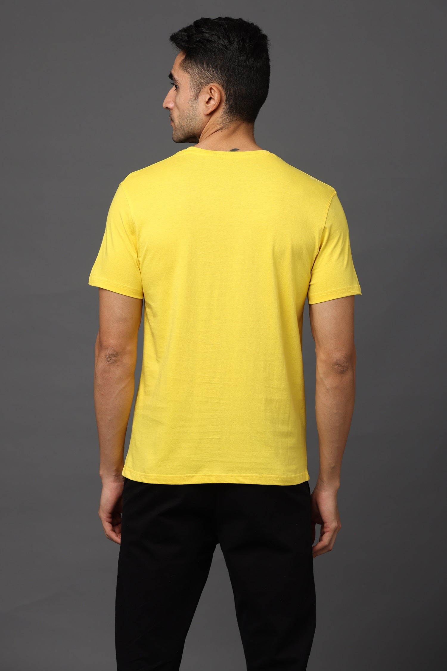 Man wearing a yellow t-shirt on a gray background