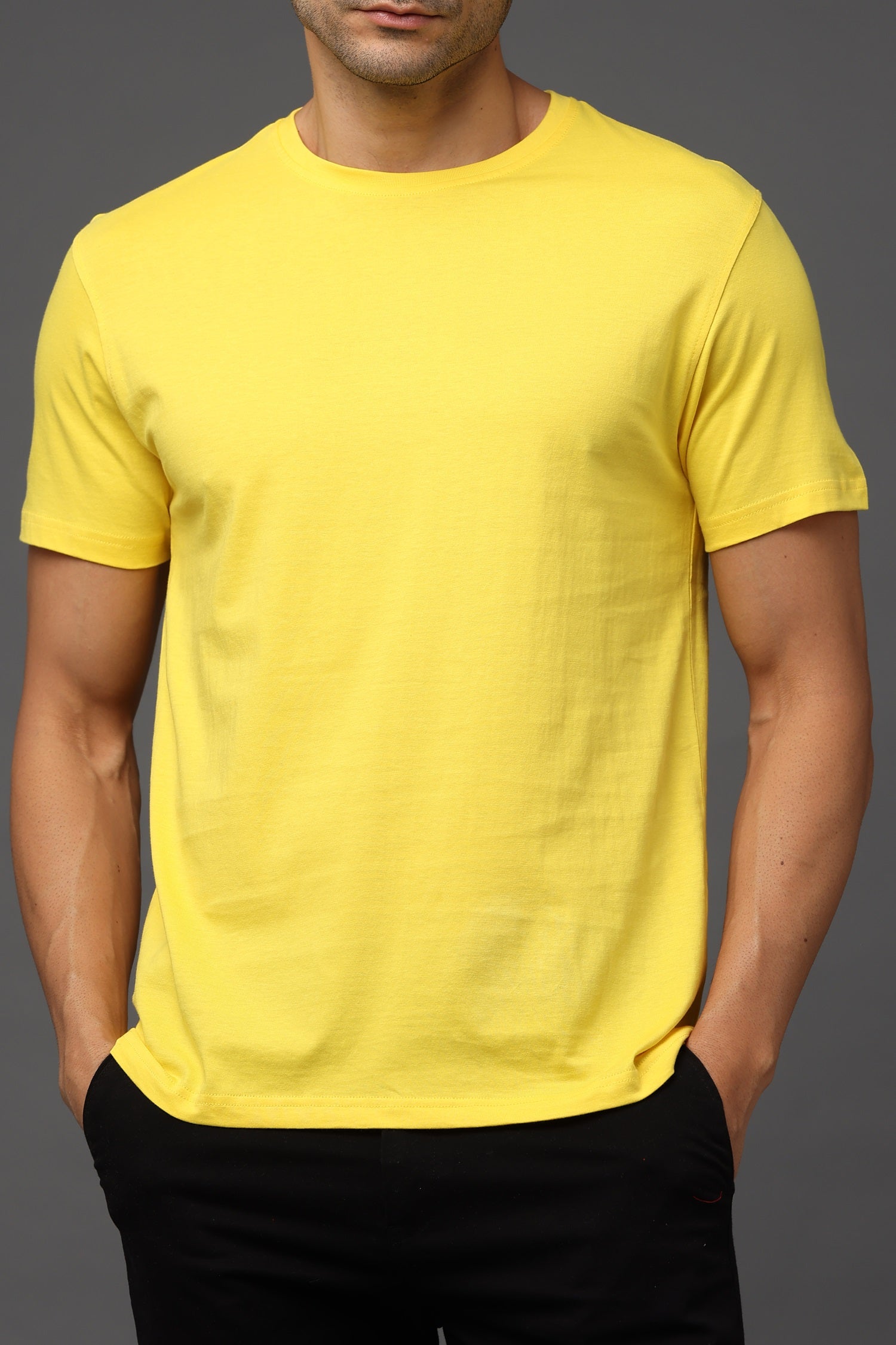 Person wearing a yellow t-shirt against a gray background